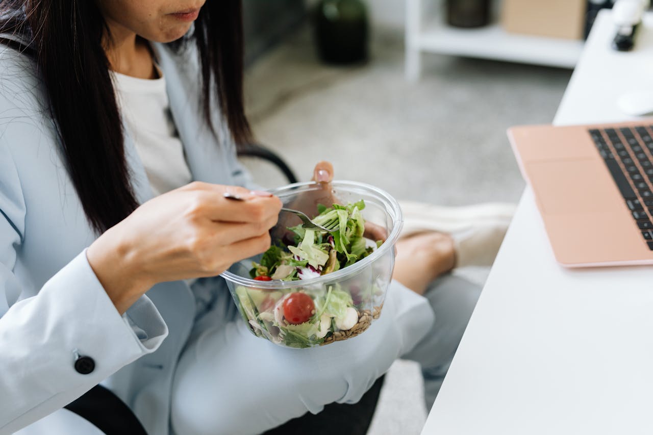 person eats salad at desk