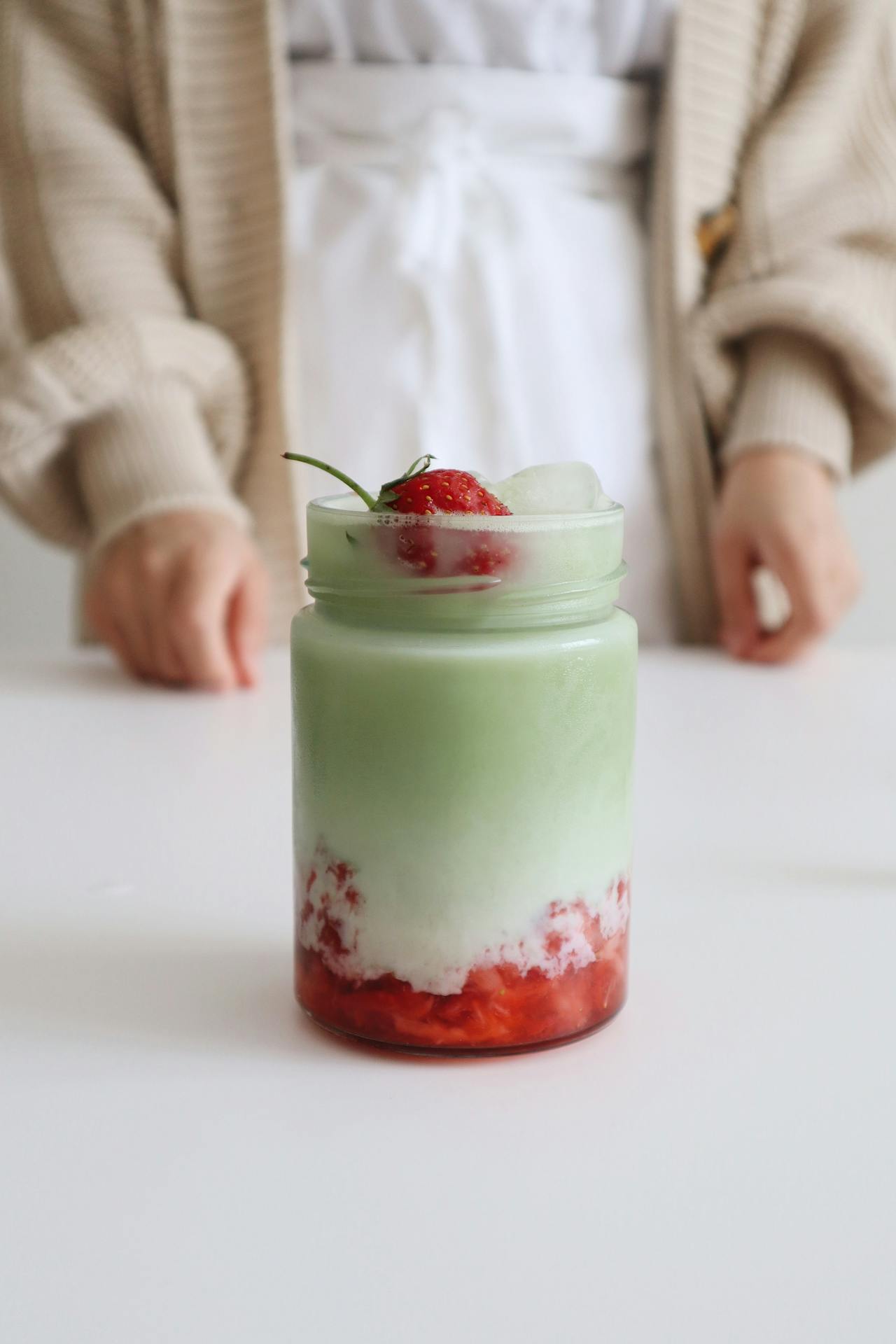 person stands in front of iced strawberry matcha
