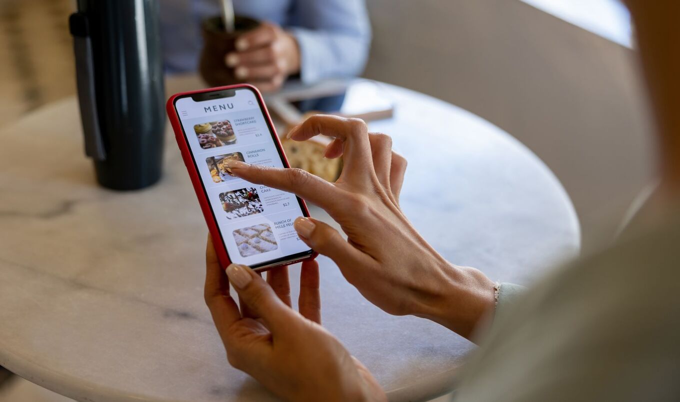 woman scrolling on phone for menu